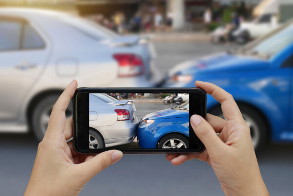 Image of a smart phone taking a picture of a car accident.